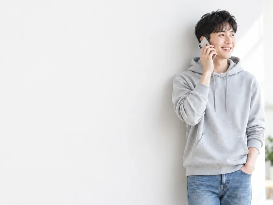 휴대폰으로 통화하는 후드티 차림 남성
